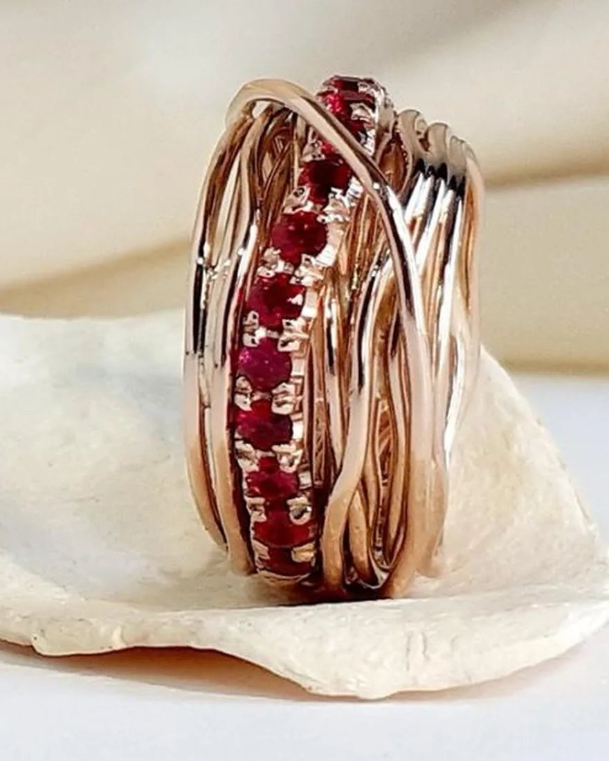 Anello multifilo in oro rosa con una fascia centrale di rubini rossi incastonati